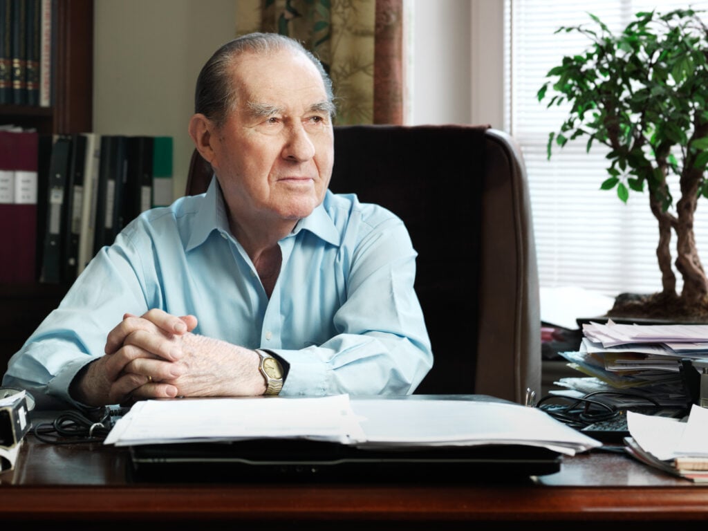 Founder Laszlo Szombatfalvy sitting in a chair in an office looking away from the camera.