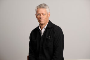 Executive Director Jens Orback is looking into the camera. He is wearing a white shirt and a sweater